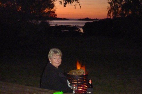 Having a drink in front of the fire as the sun sinks over Moonlight Bay.