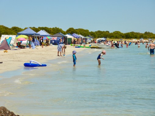 Colourful sun shelters dot the shoreline.